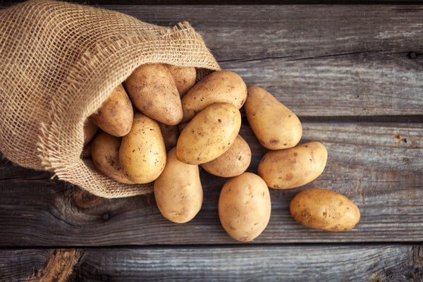 A photo of potatoes in a sack.