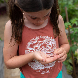A girl holding a worm in her hand.