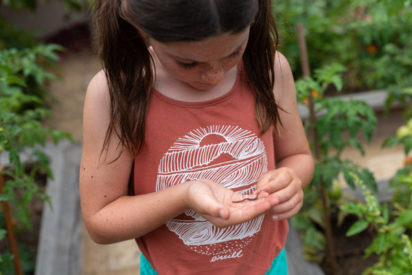 A girl holding a worm in her hand.