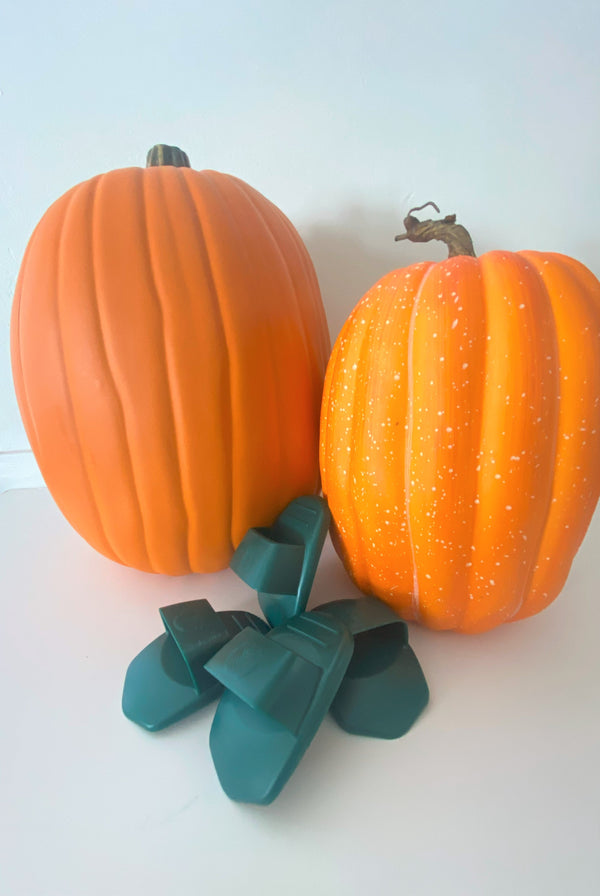 Two large pumpkins and a pile of four Pumpkin Scraper Tools. 