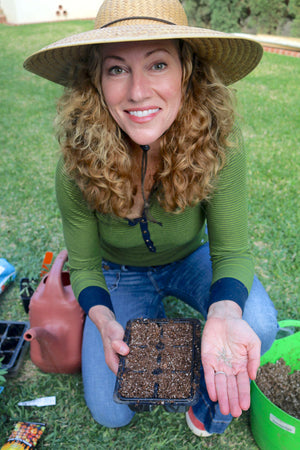 A photo of Kaitlin Mitchell holding cucumber seeds in her hand.